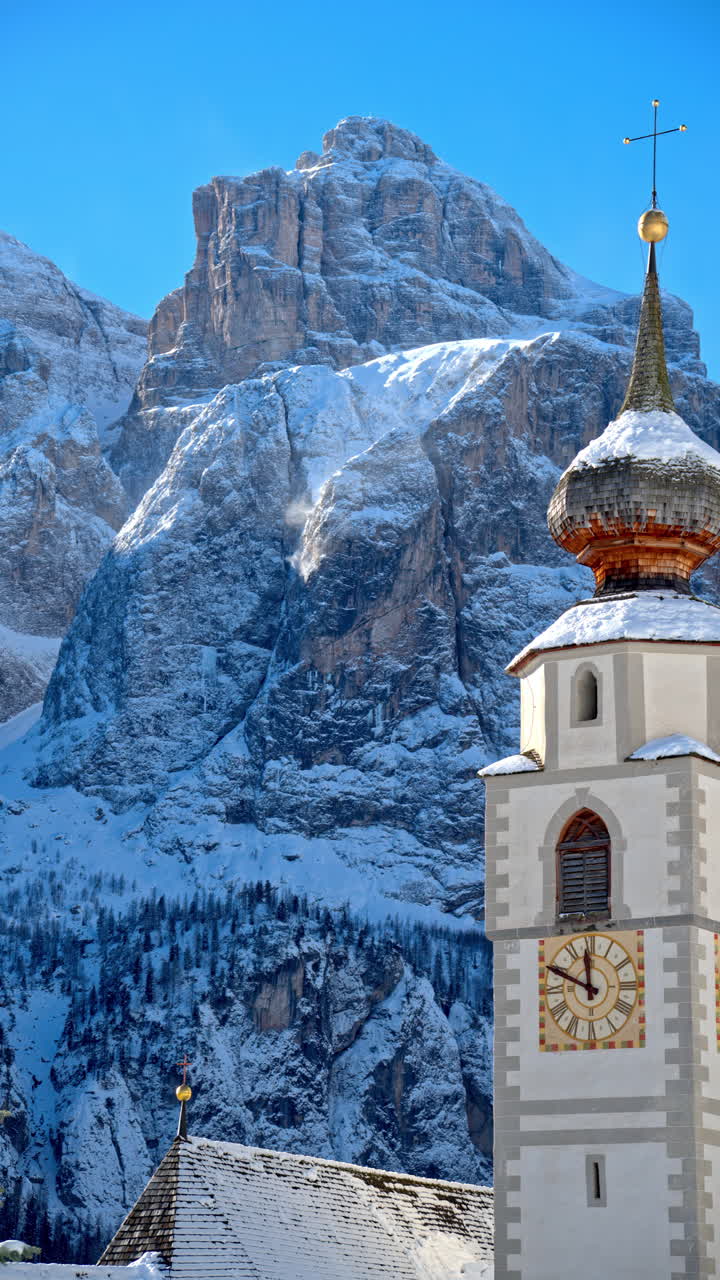 Close up of the Parrocchia di Colfosco in the Colfosco mountain village covered in snow, in South Tyrol, Dolomites, Northern Italy. Vertical