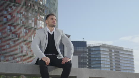 Businessman-sitting-on-bench-at-city-street.-Manager-taking-break-outside-office