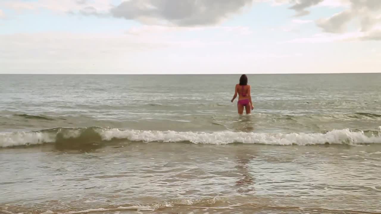 바다로 뛰어드는 에너지 넘치는 갈색 여성