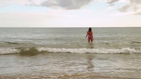 Energetic-fit-brunette-running-into-the-ocean