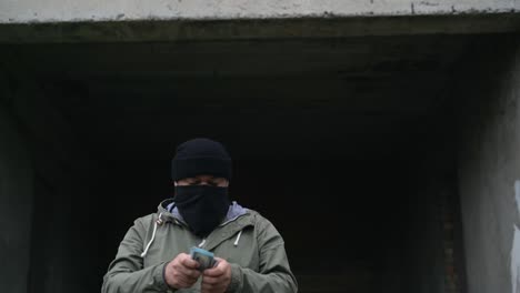 a man wearing a black face mask counts the money and puts it in his pocket. raises a poster. copy space tracking points. blank green screen board.