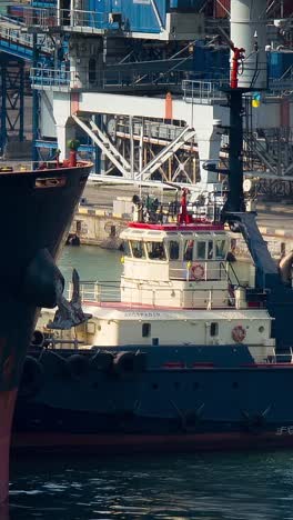 cargo ship with tugboat in the port