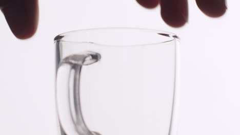 caucasian hand putting down a small coffee glass