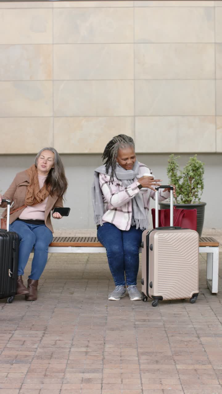 Verticale video: verschillende vrouwelijke reizigers plaatsen een koffer, controleren hun telefoon en praten op een bankje