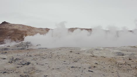 Cinematic-reveal-of-male-from-steam-vent-dense-vapor-cloud,-Iceland