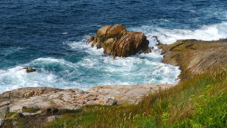 Gabbiani che volano sopra una costa rocciosa con onde selvagge. Statico.