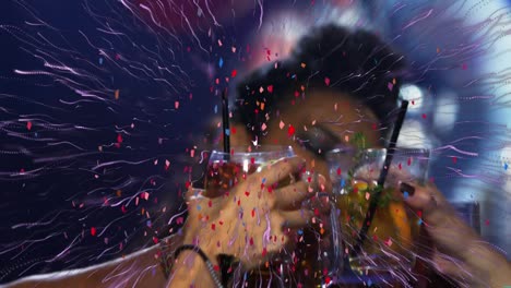 confeti y rastro de luz púrpura explotando sobre un grupo de amigos brindando sus bebidas en un bar