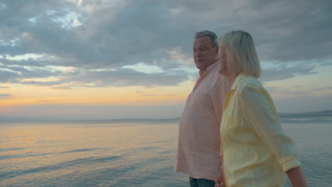 una pareja de ancianos amantes disfrutando de un paseo por la orilla del mar.