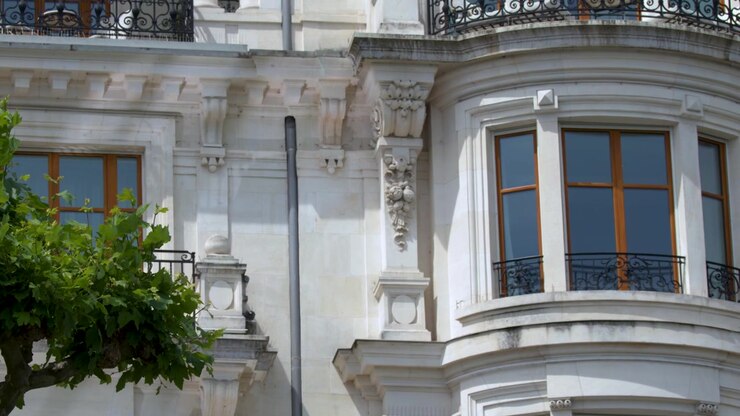 Toma panorámica de la fachada de un edificio blanco ornamentado y árboles verdes en Ginebra, Suiza