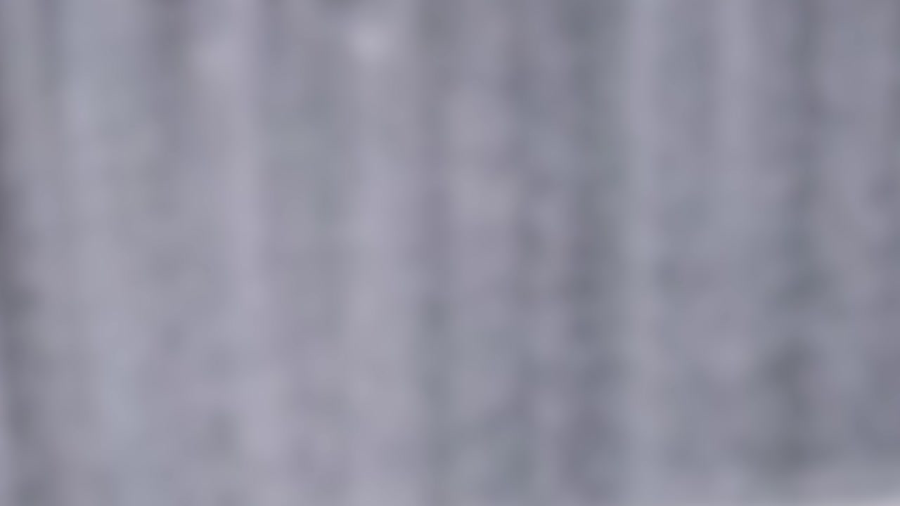 Blurred vertical lines suggest motion, resembling falling smoke or clouds with a soft, muted color palette
