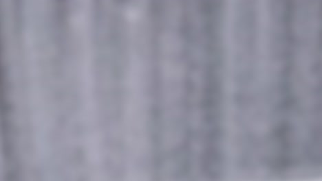 blurred vertical lines suggest motion, resembling falling smoke or clouds with a soft, muted color palette