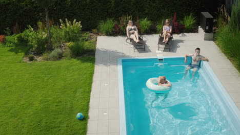 Happy-family-relaxing-by-the-pool-on-a-hot-summer-day