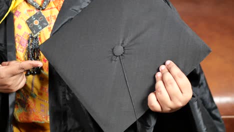 los estudiantes sostienen los sombreros en la mano durante el éxito de la graduación