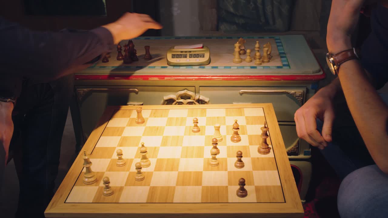 두 명의 체스 플레이어의 손이 조각을 번갈아 가며 체스 판에서 체스 조각을 가져옵니다.