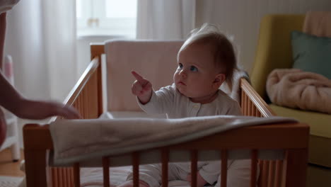 adorable baby interacting with stuffed bunny in crib