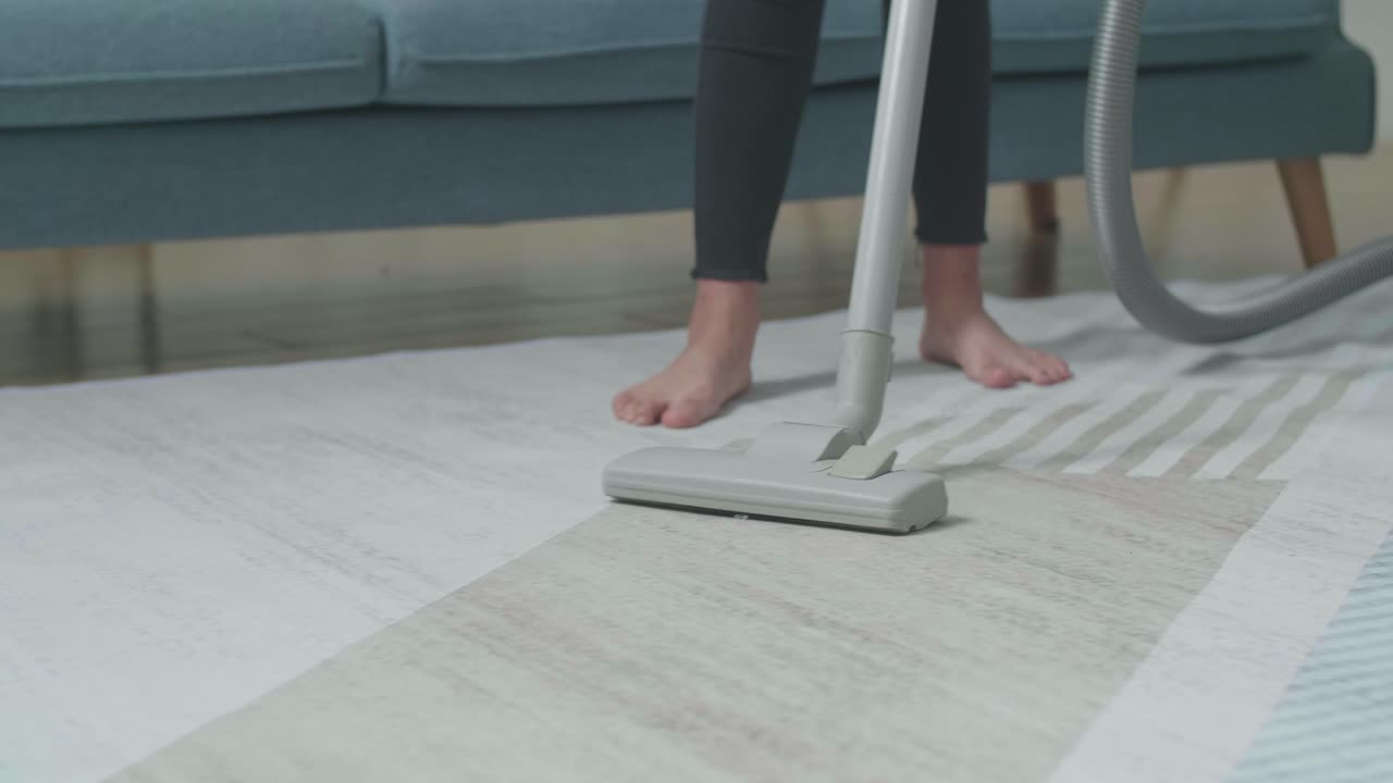 persona que está aspirando una alfombra