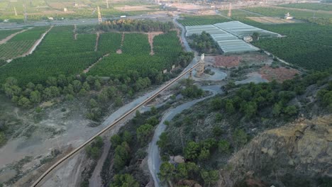 aerial view of agricultural landscape with greenhouses and industrial conveyor belt