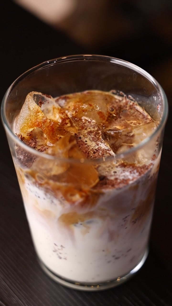 Bicchiere di caffè freddo con latte e cacao in polvere