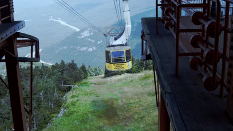 an aerial tram ascends up a cable towards the camera