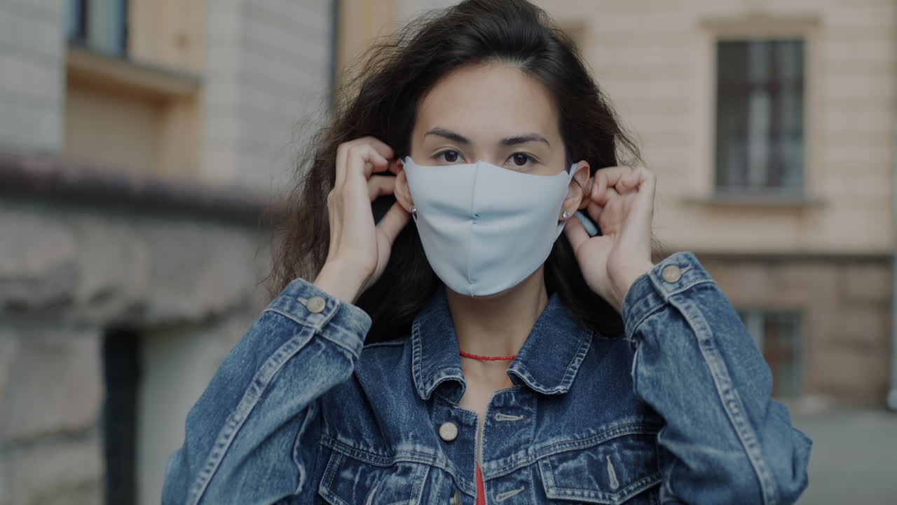 mujer ajustando la máscara facial al aire libre