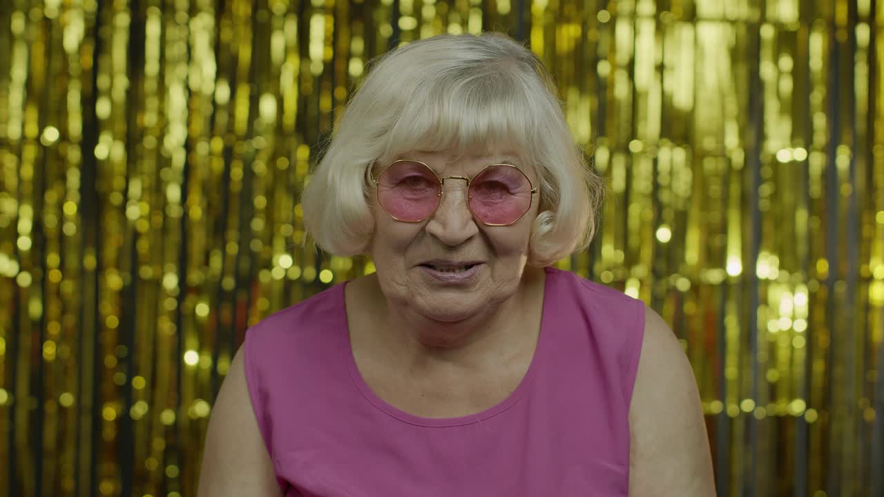 положительная старшая старуха в солнцезащитных очках наслаждается, улыбается, довольна жизнью, хорошее настроение, успех