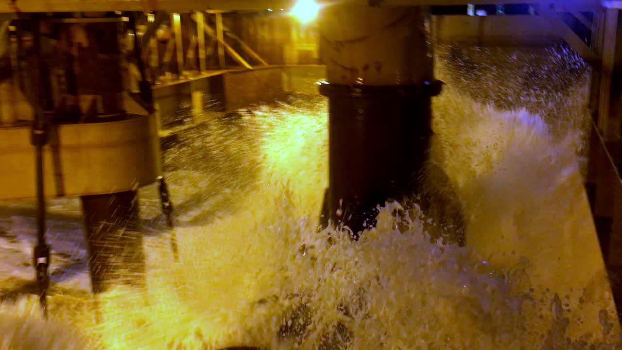 toma manual de agua que sale de una tolva de dragado durante la noche