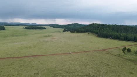 Drone-Rastreando-Camión-Blanco-En-Camino-De-Tierra-Cerca-De-Greens-Peak,-Arizona