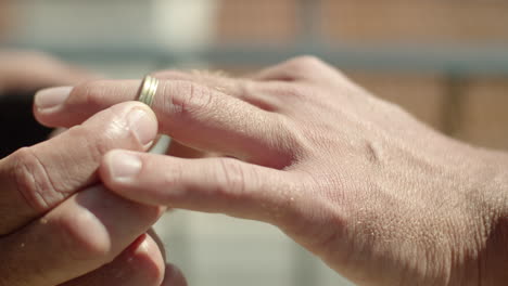 close-up shot of gay putting wedding ring on lover's finger