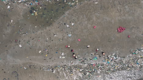 people work together to clean up rubbish covered beach, aerial top down view, ham tien vietnam