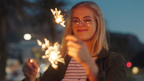 Tanzende-Teenagerin-Mit-Wunderkerzen-Am-Strand-Bei-Sonnenuntergang,-Feiert-Silvester-Und-Hat-Spaß-Bei-Der-Unabhängigkeitstagsfeier-Mit-Feuerwerk-Und-Genießt-Die-Freiheit