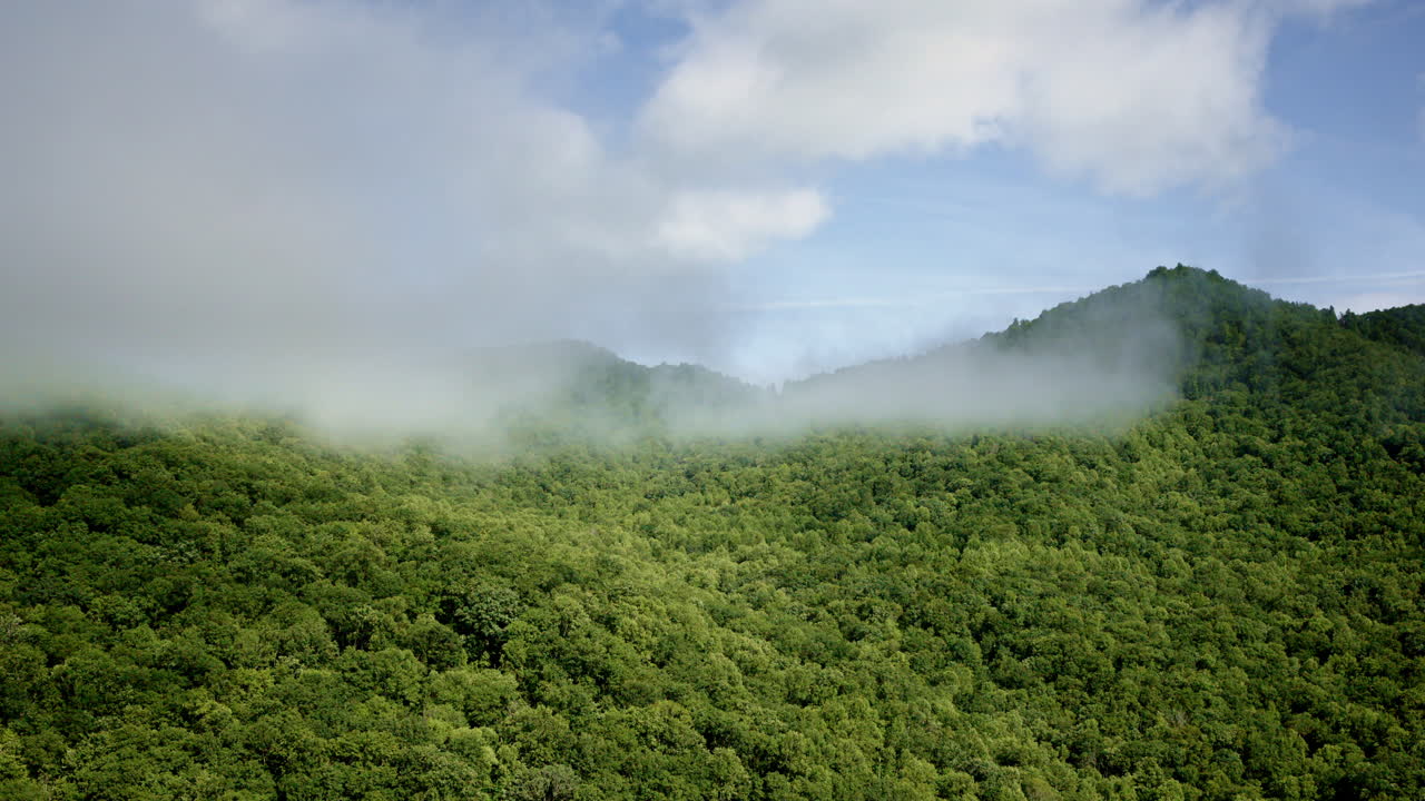 Sweeping aerial drone shot across fog-draped Smoky Mountain ridges