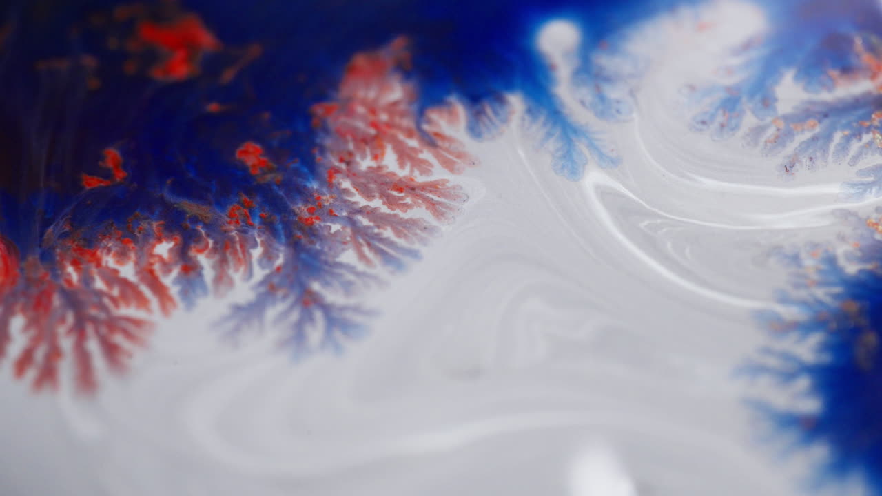 Vista macro di inchiostro colorato che si mescola creando motivi artistici