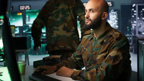 un experto del cuerpo de inteligencia controla drones que atacan objetivos.