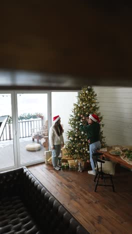 friends decorating christmas tree in a cozy living room