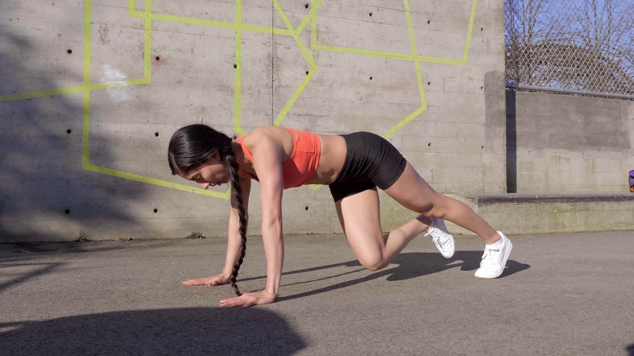 mujer atlética haciendo ejercicio de escalador de montaña al aire libre plano general