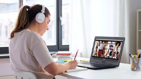 remote-job,-technology-and-people-concept--young-businesswoman-with-laptop-computer-and-papers-working-at-home-office-and-having-video-conference