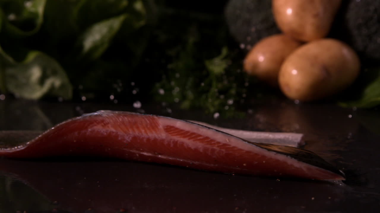 filete de trucha que cae delante de la selección de verduras