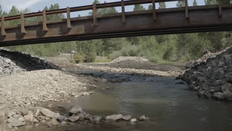 Drohnenaufnahme-Aus-Der-Luft---Langsamer-Flug-Unter-Der-Brücke-über-Den-Bach