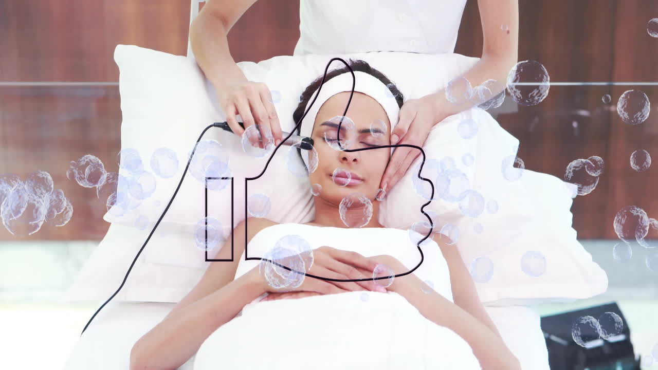 Spa professional using microdermabrasion device on client in spa room, showing animated bubbles