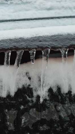 close-up of frosted car glass covered in snow and icicles during winter, capturing frozen ice details, textured surface, and cold seasonal atmosphere
