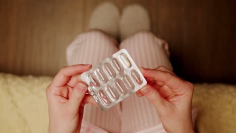 woman taking medicine in pajamas