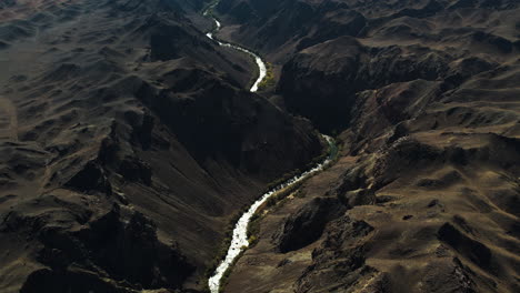 Aerial-view-tilting-over-a-river-in-the-highlands-of-Kazakhstan,-sunny-day