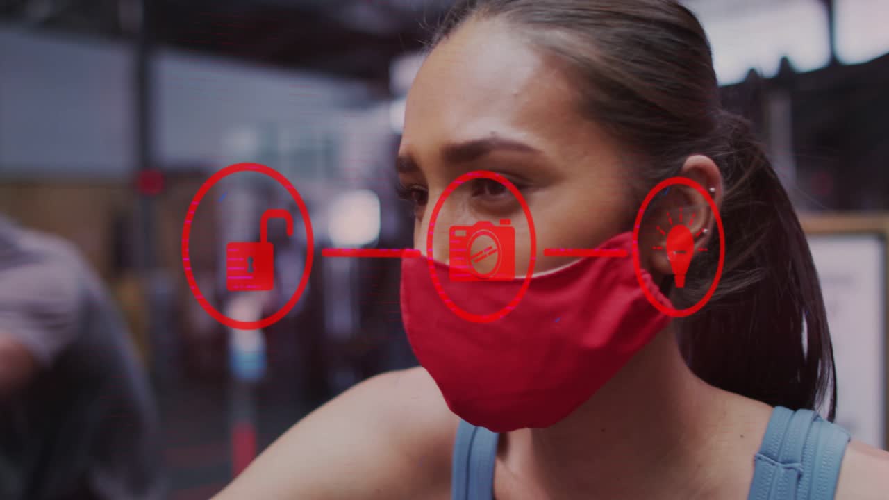 Woman wearing red mask in gym session starting red HUD icons sliding over mask signaling connection
