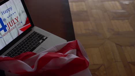 American-flags-with-inscription-Happy-Independence-Day-on-laptop