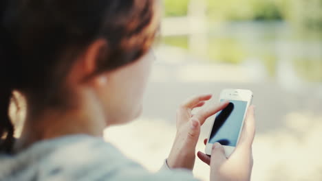 Mujer-Usando-El-Teléfono-Al-Aire-Libre-Mostrando-El-Futuro-De-La-Tecnología-Sostenible.