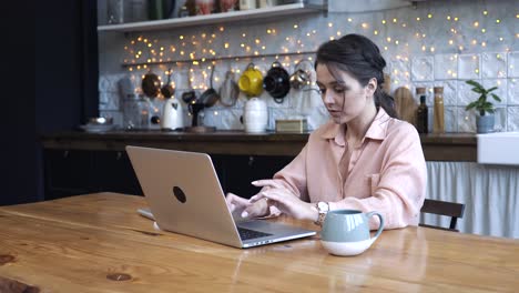 woman working on laptop in kitchen