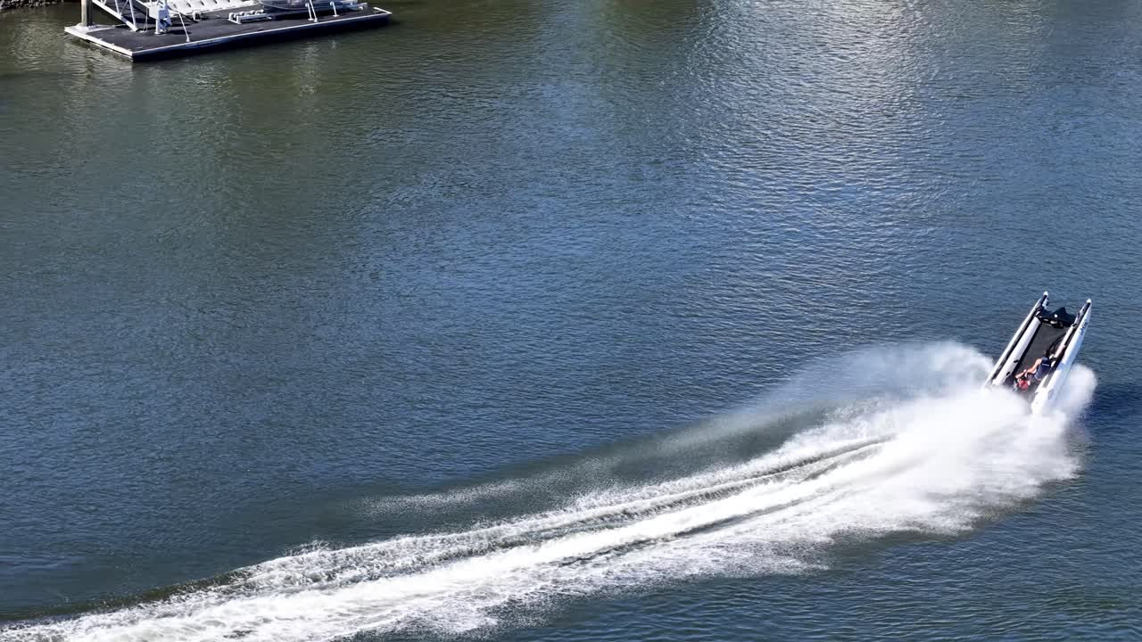 Veduta aerea di un veloce gommone che crea una scia di schiuma bianca su un fiume