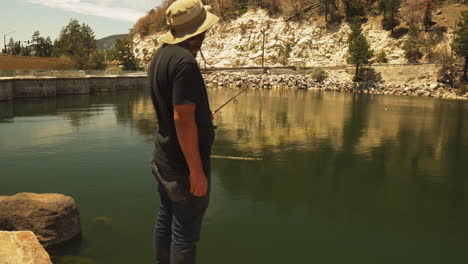 pescador de pie en un día soleado esperando pacientemente para atrapar el pez
