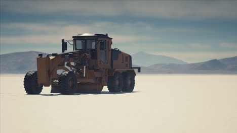 road grading machine on the salt desert road