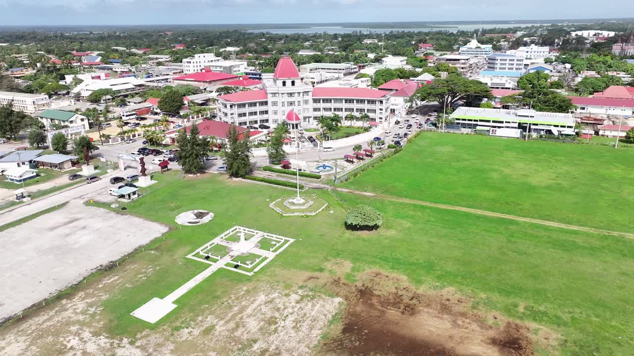 Beautiful reveal around Tongan national flag to Parliament building and Nuku'alofa cityscape. Aerial drone